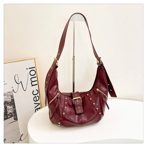 Vue détaillée du sac hobo en cuir bordeaux avec rivets dorés et boucles décoratives