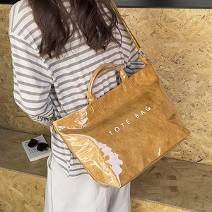 Brown tote bag in crinkled paper texture with crossbody strap and TOTE BAG print