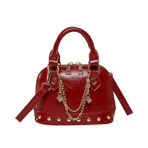 Rote Lackleder Muscheltasche mit Goldnieten und Zierkette für modische Damen
