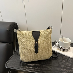Contrast straw woven crossbody bag with black leather trim and golden metal buckle detail