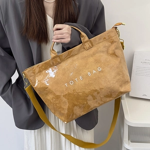 Close-up of vintage brown tote bag featuring wrinkled texture and woven wide shoulder strap