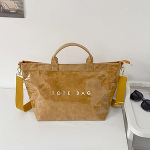 Glossy brown tote bag with wrinkled texture and yellow strap shown on white background