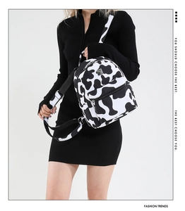 Detail view of the cow print backpack with silver hardware and adjustable straps