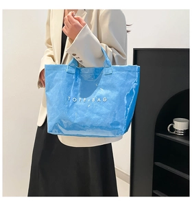 Detail showing the glossy blue waterproof Tyvek tote bag texture and white printed text