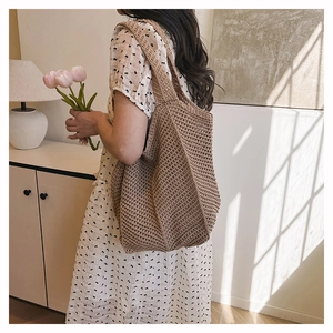 Détail du sac cabas marron crocheté à la main porté par un mannequin en style estival