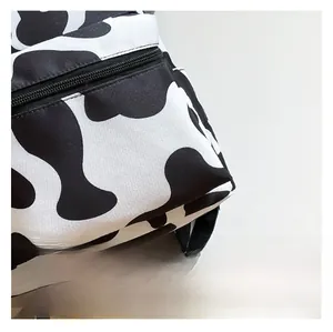 Macro detail of cow print backpack showing durable fabric texture and zipper closure