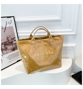 Close-up of mustard yellow waterproof Tyvek tote bag with white bold TOTE BAG text