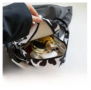 Detail showing cow print backpack interior with umbrella and daily essentials storage