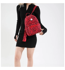 Close-up of a mini backpack featuring a bold red leopard print on durable canvas fabric
