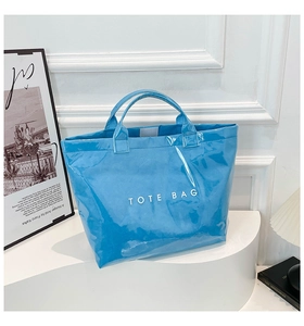 Detail of blue glossy Tyvek tote bag with white lettering and crinkled texture