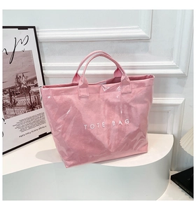 Detailed view of the pink Tyvek tote bag with waterproof texture and white lettering