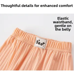 Detail of children's pink ribbed pants showing elastic waistband and Bear logo tag