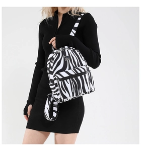 Detail of zebra print mini backpack with silver metal logo and front zipper pocket