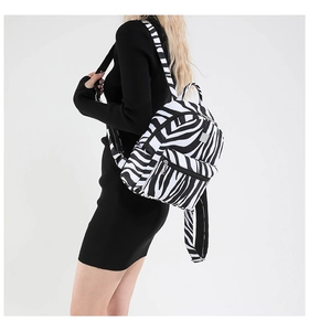 Detail view of stylish zebra print backpack with silver zipper on white background