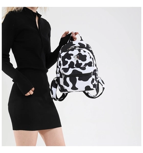 Fashionable cow print backpack featuring adjustable straps and front pocket for style
