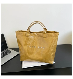 Macro shot of bright yellow waterproof Tyvek tote bag on a desk with laptop