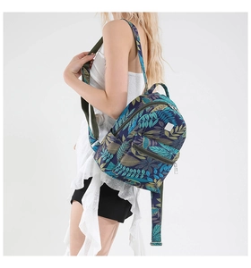 Detail view of tropical leaf pattern backpack showing compact size on female model