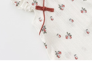 Close-up of floral girls' qipao dress with red frog buttons and knit lace texture