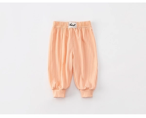 Close-up of baby ribbed joggers with elastic waist and bear patch in light orange
