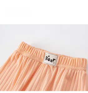 Detail of kids elastic waistband with pleated texture and cute bear logo tag