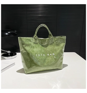 Detail of waterproof green Tyvek tote bag showing unique paper texture and white logo