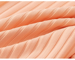 Close-up of soft ribbed knit texture on warm apricot pink cotton children pants
