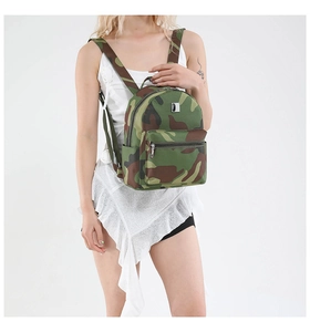 Close-up of a mini camouflage backpack with forest pattern and silver metal nameplate