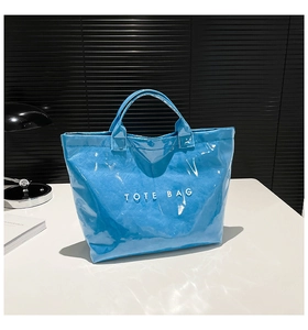 Detail of glossy waterproof bright blue tote bag with white Tote Bag text and crinkle texture