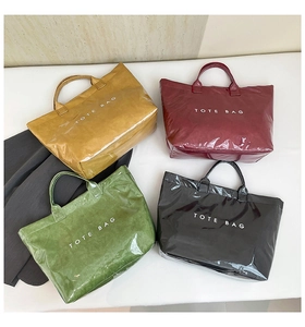 Detail of four glossy waterproof tote bags in mustard, burgundy, green and black colors