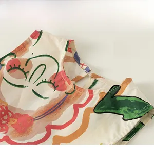 Dettaglio di un abito estivo senza maniche per bambina con scollo tondo e stampa di graffiti