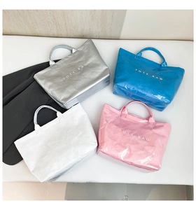 Flat lay detail of waterproof Dupont paper tote bags in silver, blue, white, and pink