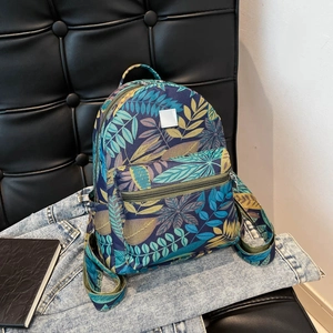 Fashionable backpack with tropical leaf print featuring main compartment and front pocket