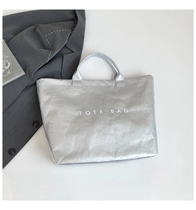 Detailed view of silver DuPont paper tote bag with printed text on a minimalist background