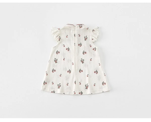Detailed view of kids' qipao dress with red cherry print and delicate ruffles