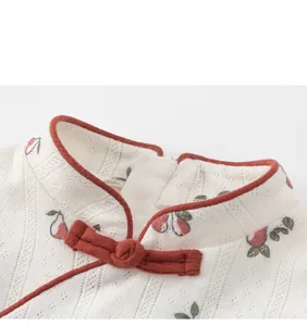 Detail of Chinese mandarin collar with handmade frog buttons and cherry jacquard fabric
