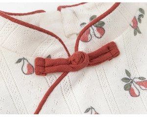 Detail of traditional Chinese knot button and red pear print on hollow knit fabric