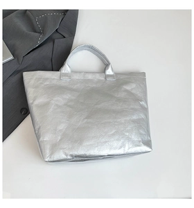 Detail of silver metallic tote bag with unique crinkled texture and minimalist top handles