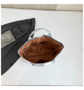 Interior view of silver Tyvek tote bag showing brown fabric lining and dual slip pockets