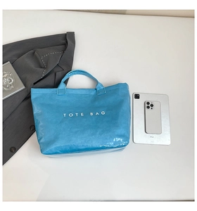 Blue Tyvek tote bag shown with an iPad and phone to demonstrate its spacious capacity