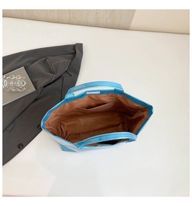 Detail view of the metallic blue Dupont paper tote with brown lining and velcro closure