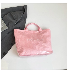 Pink Tyvek tote bag with waterproof outer layer and white Tote Bag print detail