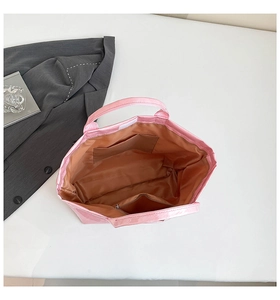 Interior view of pink glossy tote bag with brown lining and functional zip pockets
