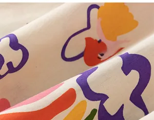 Détail du tissu en coton doux avec imprimé dessin animé sur robe chemise blanc cassé