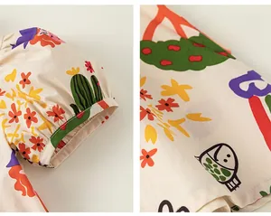 Détail de manches bouffantes et imprimés cartoon colorés sur robe en coton-lin pour enfants