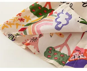 Gros plan sur l'ourlet d'une robe pour fille avec motifs arc-en-ciel et animaux colorés