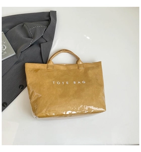 Detail of waterproof PVC tote bag featuring vintage paper texture and printed lettering