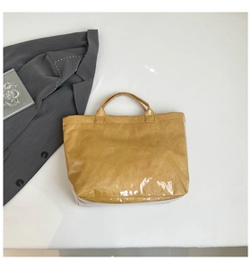 Flat lay of brown crinkled Dupont paper tote bag with glossy finish and PVC coating
