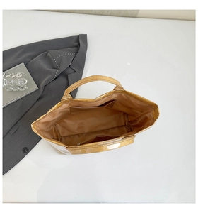 Top view of metallic gold tote bag interior with open pocket and zipper compartment