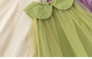 Detail of green girls dress with layered mesh tulle and a wide peter pan collar design