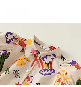 Détail du col de chemise avec imprimés de dessins animés et bouton sur tissu beige